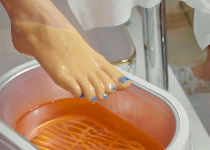Wax bath for feet at beauty spa salon, close-up. Wax bath for feet at beauty spa salon, close-up. Paraffin wax treatments for feet.